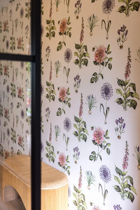 Un artisan applique de l'enduit de lissage sur un mur intérieur blanc à l'aide d'une spatule large
